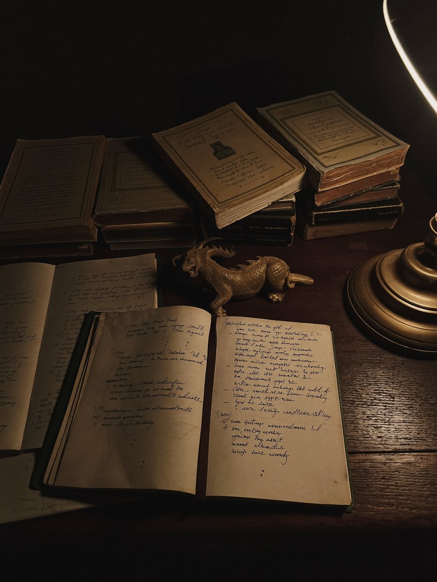 Antonia Korwin's writing desk — histories of late Rome, handwritten notes, a brass dragon by lamplight